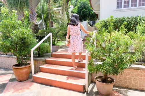 a woman walking down the stairs of a house at RQS Hostel in Tacloban