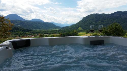 a hot tub with two glasses of wine at Ferienhaus Kaiser in Gallizien