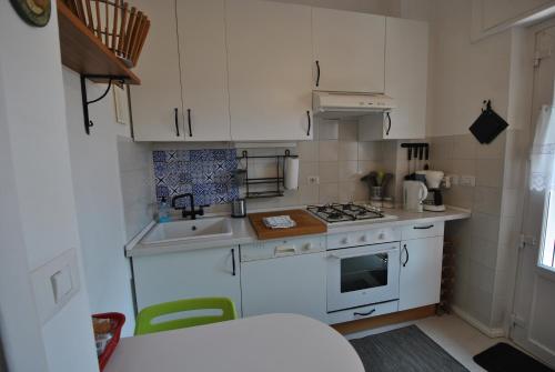 a small kitchen with white cabinets and a stove at Vigna Licia in Pomezia