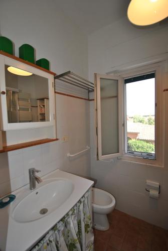 a bathroom with a sink and a toilet and a window at Vigna Licia in Pomezia