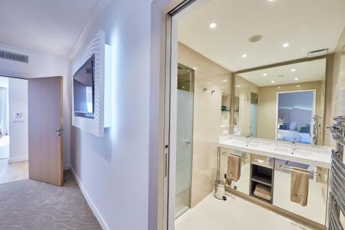 łazienka z 2 umywalkami i dużym lustrem w obiekcie Appartements La Cigale w mieście Arzon