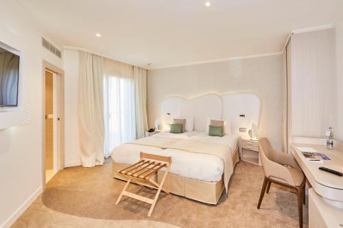 een hotelkamer met een groot bed en een bureau bij Appartements La Cigale in Arzon