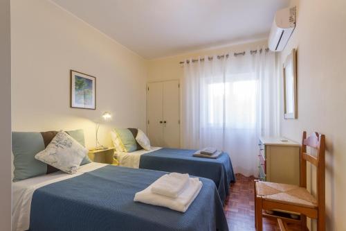 une chambre d'hôtel avec deux lits et une fenêtre dans l'établissement CHIQUITA PLACE, Praia da Luz, à Luz
