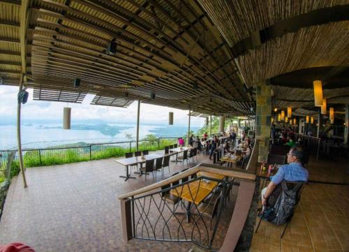 un restaurante con vistas al océano y gente sentada en las mesas en Hunaja's Home at Wind Residences TAGAYTAY en Tagaytay