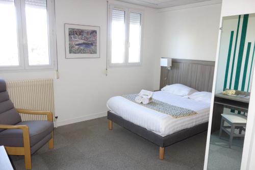 a bedroom with a bed and a desk and a chair at Hostellerie Bon Pasteur in Angers