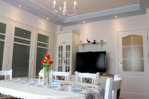 ein Esszimmer mit einem Tisch und einem TV in der Unterkunft Central Varna Apartment - Lets4Holiday in Warna