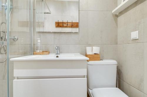 a white bathroom with a sink and a toilet at Madragoa Cosy Apartment in Lisbon