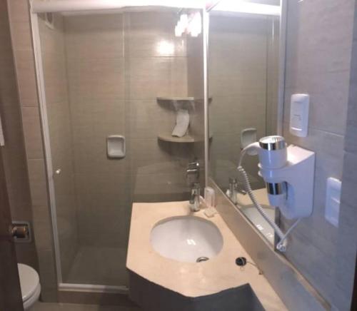 een badkamer met een wastafel en een douche bij Hotel Camelot in Punta del Este