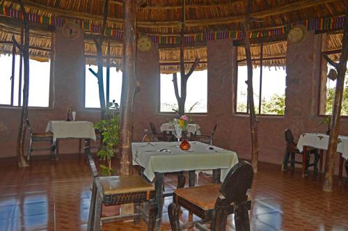 a dining room with tables and chairs and windows at Old Abyssinia Lodge in Lalībela