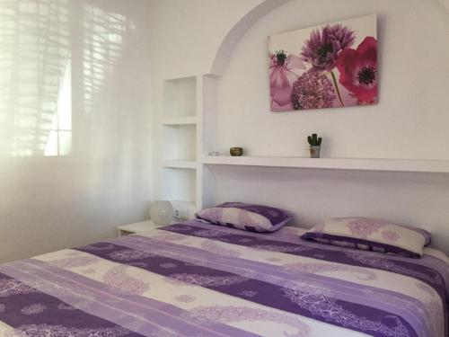 プレヤス・デ・オリフエラにあるPlaya Flamencaの紫のシーツと花が飾られたベッドルーム1室が備わります。