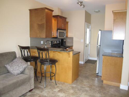 a living room with a couch and a kitchen at Sandy Beach Suites in Osoyoos