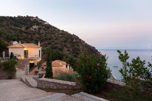 a house on a hill next to the water at Kissakas Villas in Leonidion