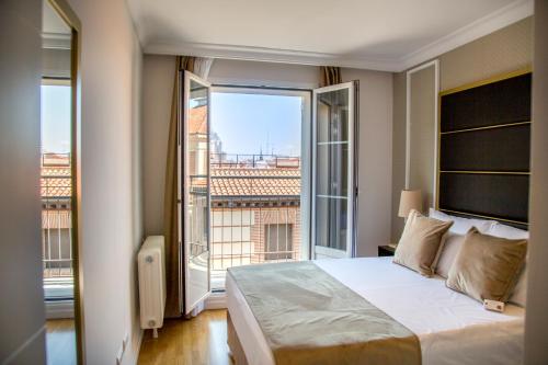 
a hotel room with a bed and a window at L&H Gran Vía Selection in Madrid
