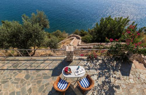 a table and chairs on a patio overlooking the ocean at Kissakas Villas in Leonidion