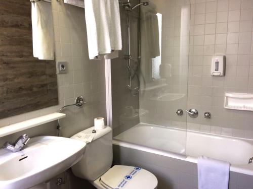 a bathroom with a toilet and a sink and a shower at Hotel Alda Centro Ponferrada in Ponferrada