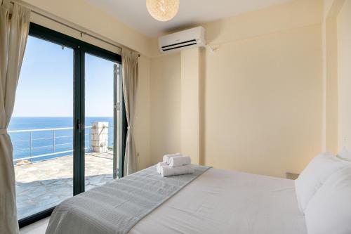 a bedroom with a bed and a view of the ocean at Kissakas Villas in Leonidion