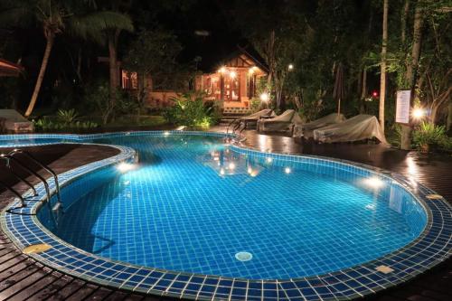 a large blue swimming pool at night at Marisa Resort & Spa Chiang Dao in Ban Muang Ngai