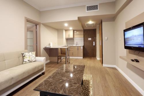 a living room with a couch and a flat screen tv at New Balturk Hotel Izmit in Kocaeli