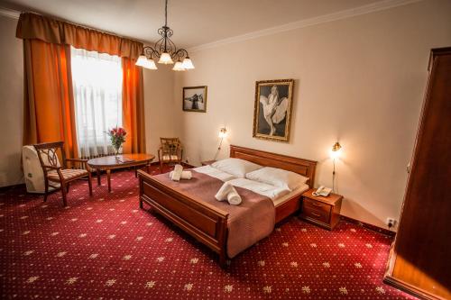 a bedroom with a bed and a table and chairs at Film Hotel in Bratislava