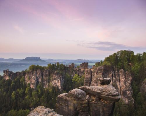 a person sitting on a rock at the top of a mountain at Trapani glamping camp in Růžová