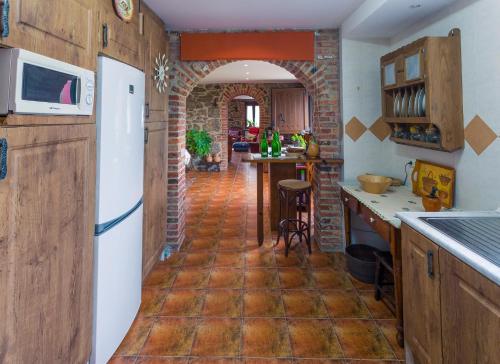 a kitchen with a white refrigerator and a brick wall at Casa La Escuela in Tuilla