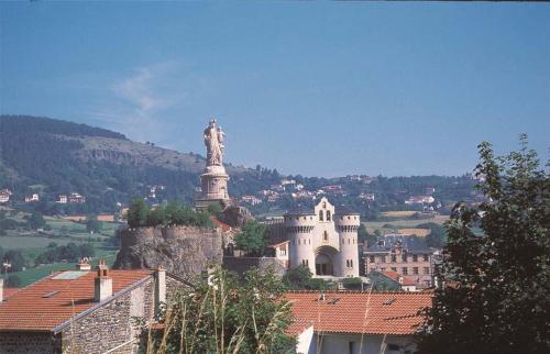 a building with a statue on top of a mountain at La maison D'Orée in Polignac