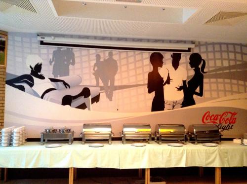 a table in a restaurant with a large picture on the wall at Hotel Sommerhaus Linz in Linz