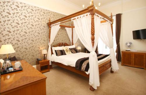 a bedroom with a four poster bed with a canopy at Woodlands Hotel, BW Signature Collection in Dundee