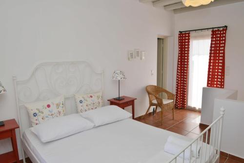 a bedroom with a white bed and a chair at Country Villas in Stelida