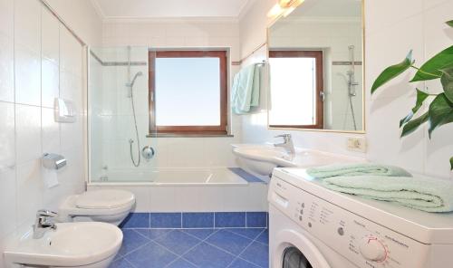 a bathroom with a sink and a toilet and a tub at Apartment Gertrud in Castelrotto