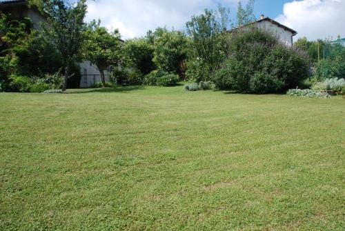 a large yard with green grass and a house at la casa in collina in Vicoforte