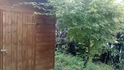 a wooden fence with a tree next to it at Stephanie Home in Padova
