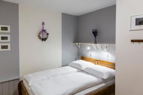 コシチェリスコにあるudanypobyt Apartament Regionalny z tarasemの白いベッドルーム(白いシーツ付きのベッド1台付)