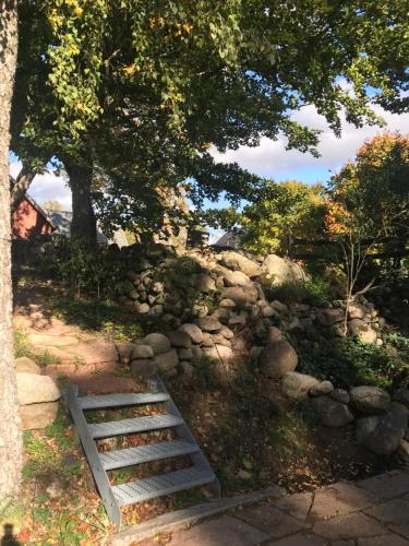 a stone wall and a stairway next to a tree at The Old Henhouse in Tollarp