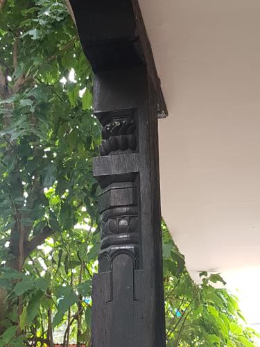 a wooden pole with a carving on the side of it at Shaligram Hotel in Pātan