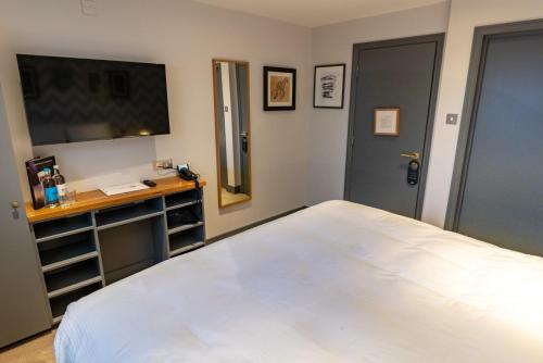 a bedroom with a large white bed and a desk at Albert Arms in Esher