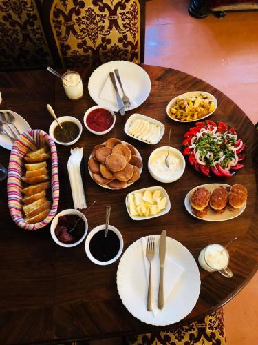 a wooden table with plates of food on it at Travel Inn House Mestia • მოგზაურის სახლი in Mestia