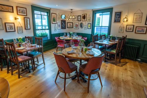 a dining room with wooden tables and chairs at Albert Arms in Esher