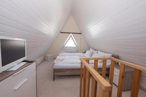 a room with a bed and a tv and a window at Ferienwohnungen Hofmann in Zingst