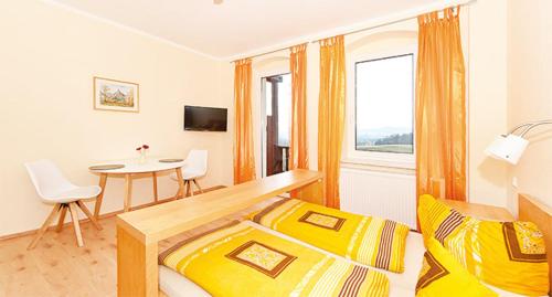 1 dormitorio con cama, mesa y ventana en Panorama-Apartments Weinberghaus en Mittelndorf