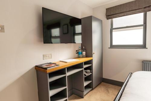 a bedroom with a desk and a mirror at Albert Arms in Esher