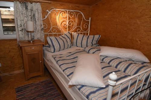 a bed with striped pillows in a room at kleines Appartment auf Gestütsanlage in Drangstedt