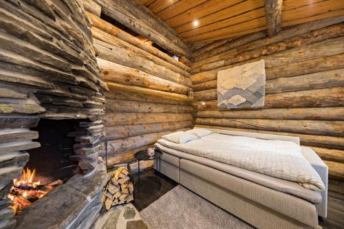 a bedroom in a log cabin with a fireplace at UnelmaKaukelo in Ruka
