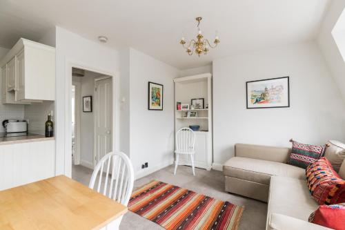 a living room with a couch and a table at JOIVY Cosy 1 bed flat with balcony in Pimlico, next to Warwick Square in London