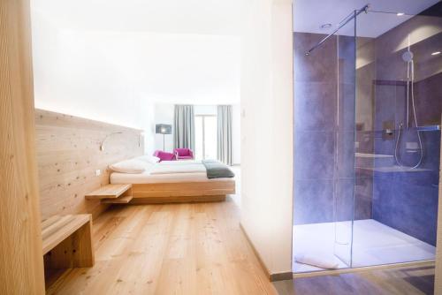 a bathroom with a bed and a glass shower at Vegan Hotel La Vimea in Naturno