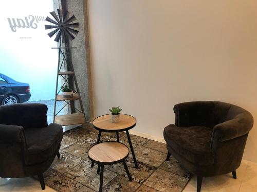 Una habitación con dos sillas y una mesa y un molino de viento. en Mystay Porto Batalha, en Oporto