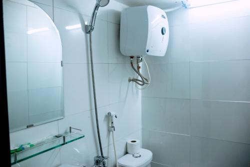 a bathroom with a shower and a toilet and a mirror at Thanh An 2 Guesthouse in Hue