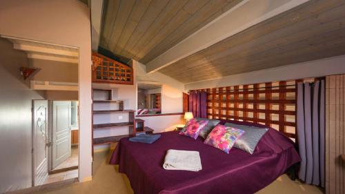 a bedroom with a purple bed in a room at les palmiers des causses in Saint-Rome-de-Tarn