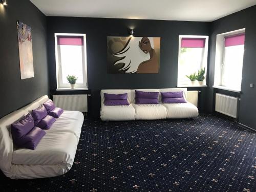 a living room with two white couches and purple pillows at SPA Hotel in Vorzelʼ