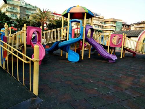 a playground with colorful slides and an umbrella at Best Home 20 Cleopatra Select in Alanya